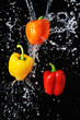 Three peppers water splash on black