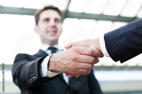 Photo: Image of business handshake at the office Image of business handshake at the office