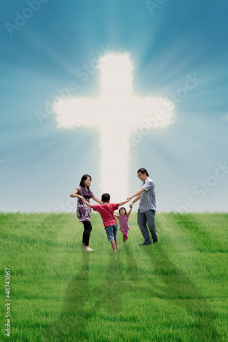 Photo: Christian family at bright Cross Christian family at bright Cross