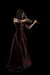 young asian woman playing the violin on black
