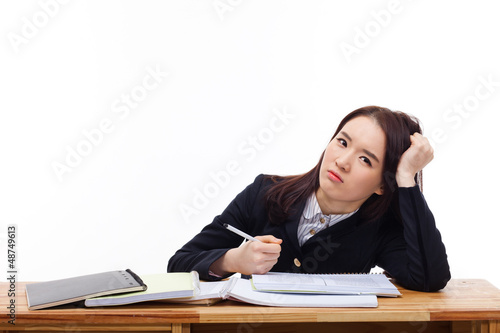 Photo: Young Asian student having trouble on desk. Young Asian student having trouble on desk.