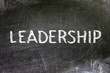 Leadership handwritten with white chalk on a blackboard.