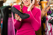 Woman is buying shoes for her Tracht or dirndl in a shop