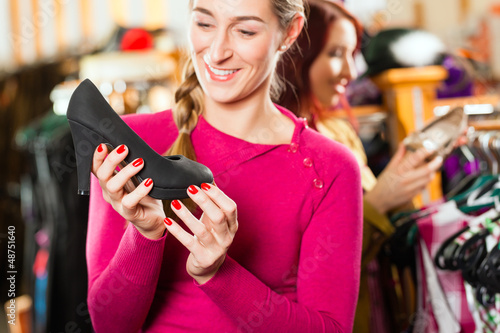Photo: Woman is buying shoes for her Tracht or dirndl in a shop Woman is buying shoes for her Tracht or dirndl in a shop
