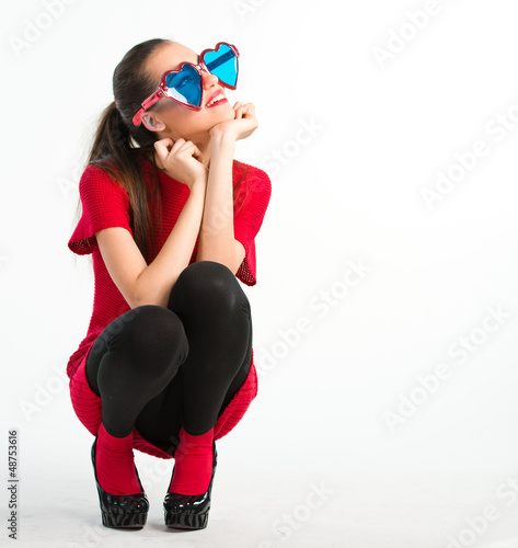 Photo: Young woman in red with heart shaped glasses Young woman in red with heart shaped glasses