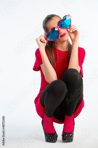 Photo: Young woman in red with heart shaped glasses Young woman in red with heart shaped glasses