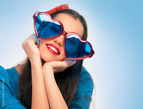 Photo: Portrait of a beautiful woman in blue with heart shaped glasses Portrait of a beautiful woman in blue with heart shaped glasses