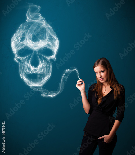 Photo: Young woman smoking dangerous cigarette with toxic skull smoke Young woman smoking dangerous cigarette with toxic skull smoke
