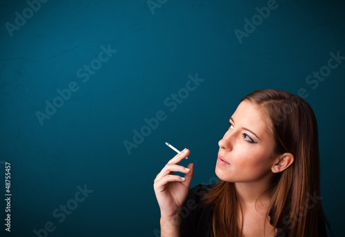 Photo: Beautiful woman smoking cigarette vith copy space Beautiful woman smoking cigarette vith copy space