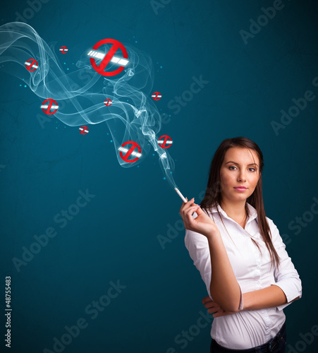 Photo: Young woman smoking dangerous cigarette with no smoking signs Young woman smoking dangerous cigarette with no smoking signs
