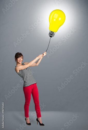 Photo: Pretty lady holding a light bulb balloon Pretty lady holding a light bulb balloon