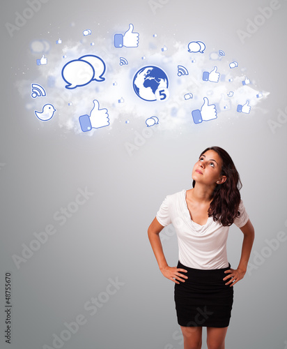 Photo: pretty woman looking social network icons in abstract cloud pretty woman looking social network icons in abstract cloud