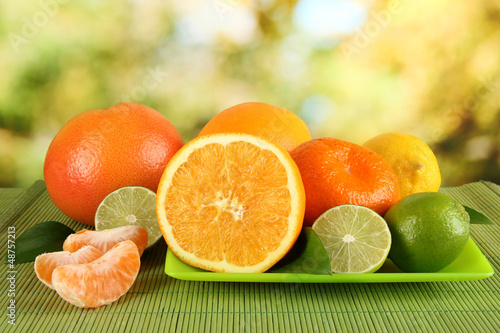 Photo: Fruits with leafs on table on bright background Fruits with leafs on table on bright background