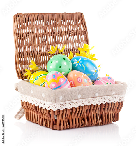 Photo: easter eggs in basket with yellow flowers isolated on white easter eggs in basket with yellow flowers isolated on white