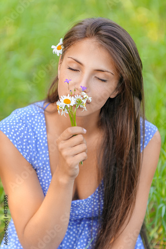 Photo: young woman smelling bouquet of daisies young woman smelling bouquet of daisies