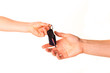 Photo: Male hand holding a car key and handing it over isolated Male hand holding a car key and handing it over isolated