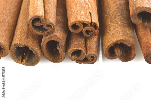 Photo: cinnamon sticks stacked on the white background cinnamon sticks stacked on the white background