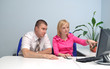 girl shows something on the monitor to a colleague
