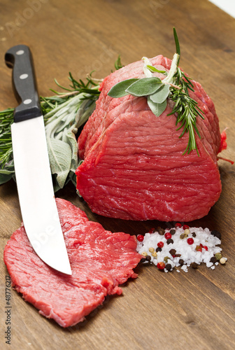 Photo: Raw beef on wooden table Raw beef on wooden table