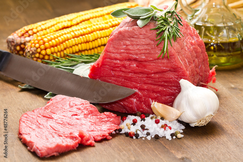 Photo: Raw beef on wooden table Raw beef on wooden table