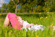 Mother playing with baby on meadow
