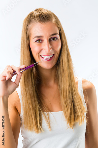 Photo: Woman brushing her teeth with toothbrush Woman brushing her teeth with toothbrush