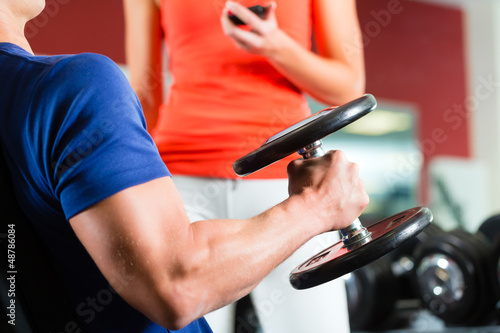 Photo: Personal Trainer in gym and dumbbell training Personal Trainer in gym and dumbbell training