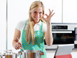Woman in home kitchen using electronic tablet for cooking