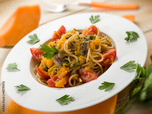 Photo: spaghetti with pumpkin anchovy caper tomatoes, selective focus spaghetti with pumpkin anchovy caper tomatoes, selective focus