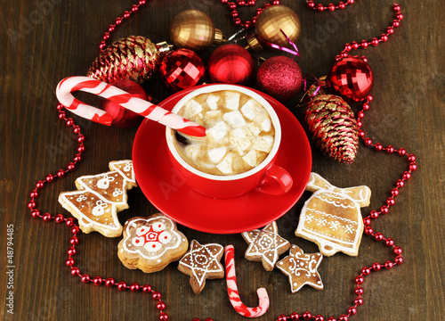 Photo: Cup of coffee with Christmas sweetness on wooden table close-up Cup of coffee with Christmas sweetness on wooden table close-up