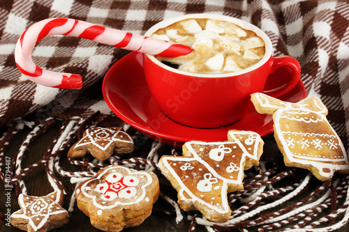 Photo: Cup of coffee with Christmas sweetness on plaid close-up Cup of coffee with Christmas sweetness on plaid close-up