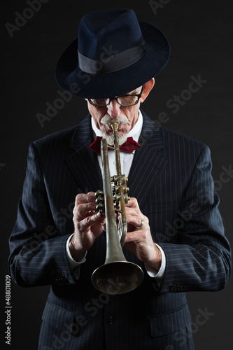 Photo: Senior jazz musician. Trumpet player. Studio shot. Senior jazz musician. Trumpet player. Studio shot.