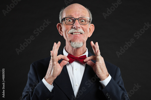 Photo: Funny senior man wearing suit and red tie. Funny senior man wearing suit and red tie.