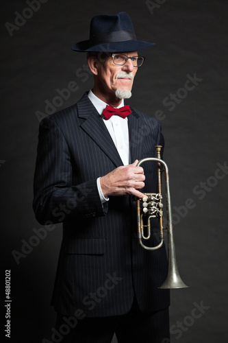 Photo: Senior jazz musician. Trumpet player. Studio shot. Senior jazz musician. Trumpet player. Studio shot.