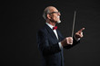 Senior conductor wearing suit. Studio shot.