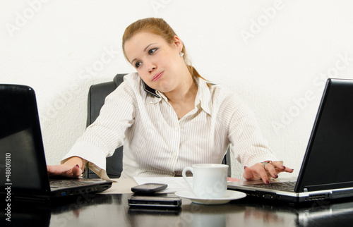 Photo: Stressed business woman multitasking in her office Stressed business woman multitasking in her office
