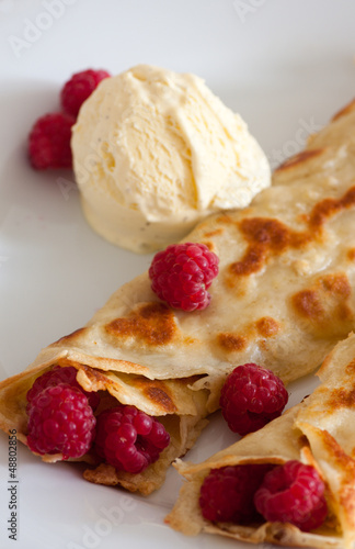 Photo: Crepes with raspberries and vanilla ice cream on a white plate Crepes with raspberries and vanilla ice cream on a white plate