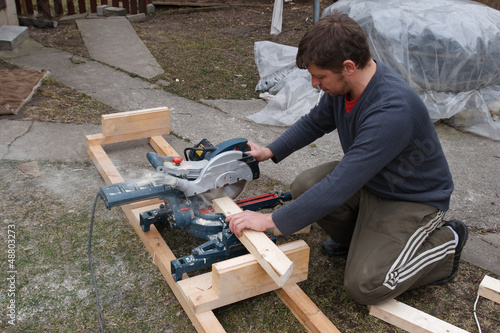 Photo: Carpenter sawing plank Carpenter sawing plank