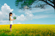 Foto: Little girl holding earth with recycle symbol at flower field Little girl holding earth with recycle symbol at flower field