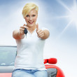 Photo: Beautiful young women shows thumb up with her electric roadster Beautiful young women shows thumb up with her electric roadster