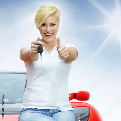 Photo: Beautiful young women shows thumb up with her electric roadster Beautiful young women shows thumb up with her electric roadster