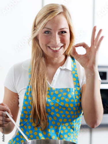 Photo: Beautiful young woman tasting her self prepared meal Beautiful young woman tasting her self prepared meal