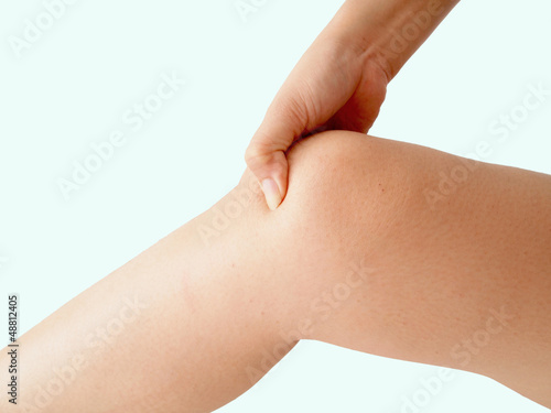 Photo: woman holding sore knee, isolated on white background woman holding sore knee, isolated on white background