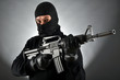 Maskierter Mann mit Maschinengewehr