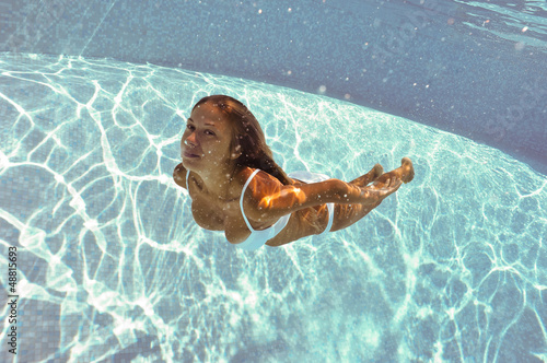 Photo: Girl portrait posing underwater with white bikini. Girl portrait posing underwater with white bikini.