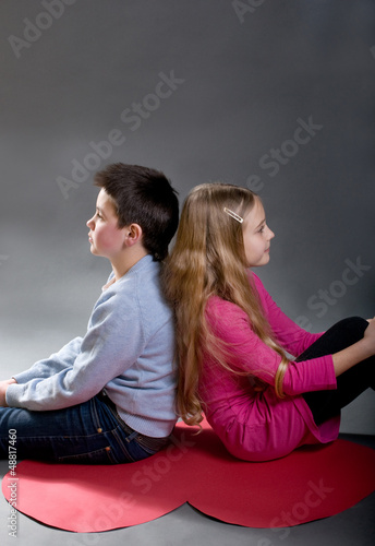 Photo: The children are sitting back to back The children are sitting back to back