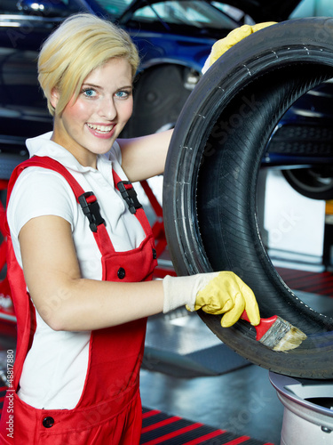 Photo: Female apprentice preparing a tire Female apprentice preparing a tire