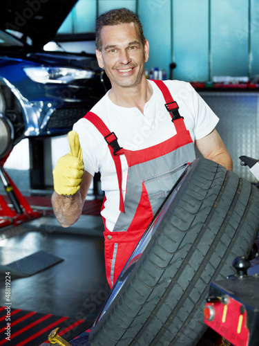 Photo: Car mechanic shows thumb up for his job Car mechanic shows thumb up for his job