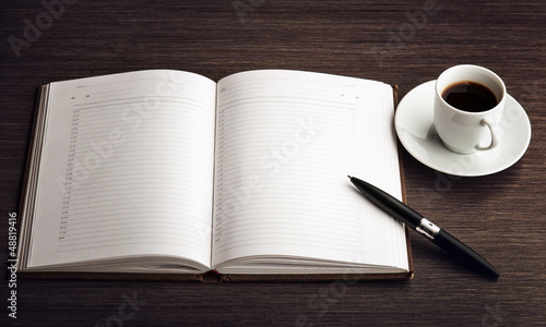 Photo: Open a blank white notebook, pen and coffee on the desk Open a blank white notebook, pen and coffee on the desk
