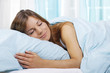 Glückliche Frau schläft im Bett
